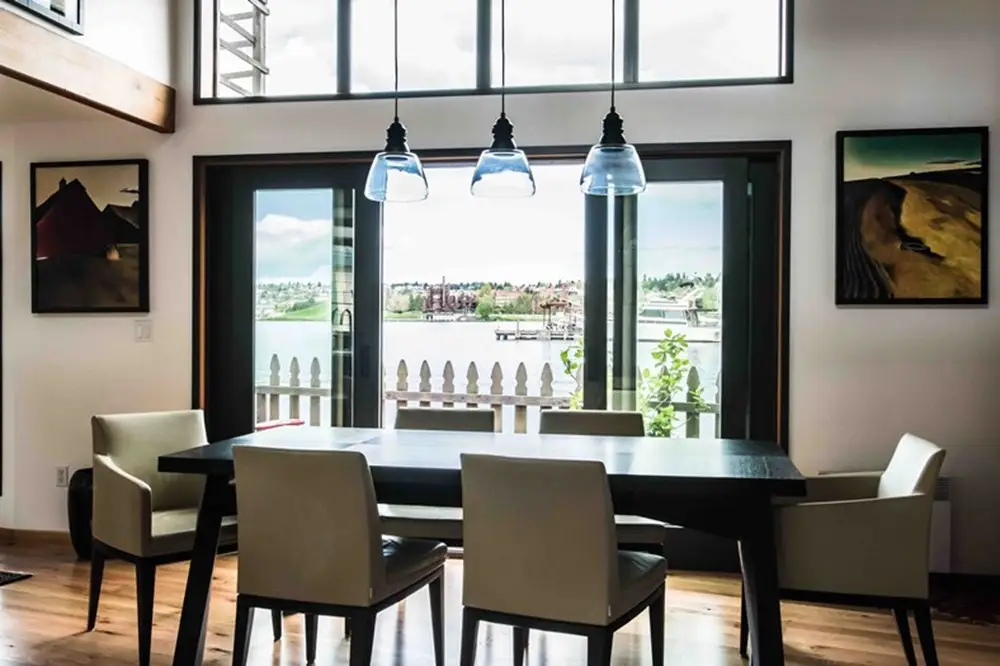 Dining area overlooking the water through large windows with abundant natural light.